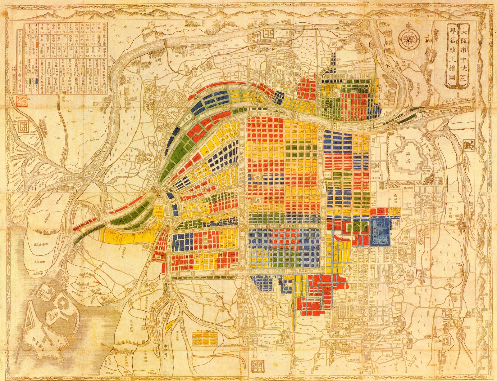 The new administrative districts, washed in flat red, blue, yellow and green over the old street grid, which shows through underneath in brown line. What is under the colour is the Edo city: same grid, same canals, largely the same names. The colour groups blocks for taxation, conscription, policing and the census.<br><br>Mapping Osaka had been a trade for two hundred years. From the 1870s the government does it instead, for its own purposes. It neither surveyed nor drew the city on this sheet; it coloured in a map of it to record a renaming it had imposed. Nothing on the ground moved.